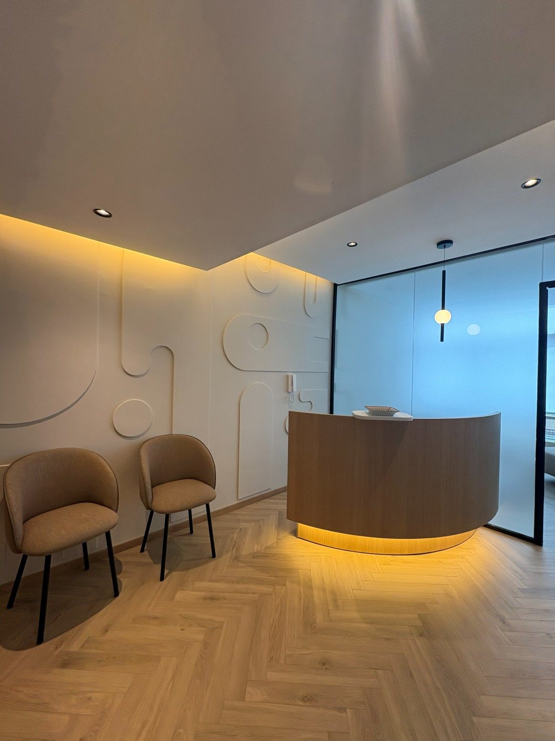 Salle d'attente du cabinet de psychologie à Casablanca — fauteuils et banque d'accueil en bois